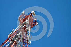 Mobile phone cellular telecommunication radio tv antenna tower against blue sky