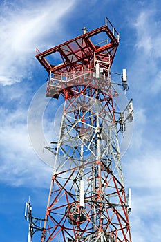 Mobile Phone Cellular Tower against blue sky and white clouds