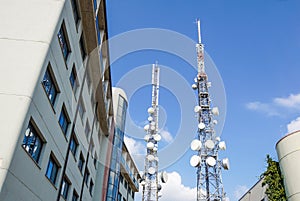 Mobile phone communication antenna tower with satellite dish on blue sky background, Telecommunication tower