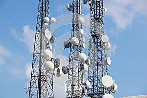 Mobile phone communication antenna tower with satellite dish on blue sky background, Telecommunication tower