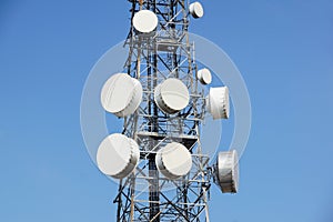 Mobile phone communication antenna tower with satellite dish on blue sky background, Telecommunication tower