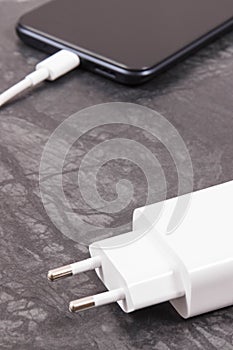 Mobile phone with connected plug of charger. Smartphone charging