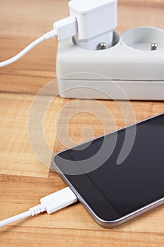 Mobile phone with connected plug of charger, smartphone charging