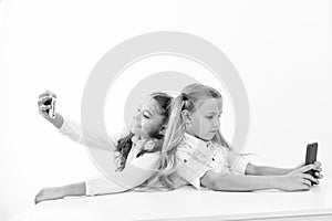 Mobile phone dependence and selfie. small kids make selfie on phone at school isolated on white, copy space. students