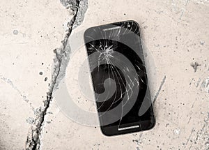 Mobile phone device scratched and broken crack touch screen abandoned on street concrete ground in repair and fix smart phone serv