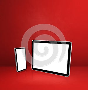 Mobile phone and digital tablet pc on red office desk