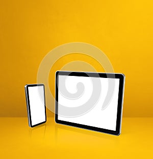 Mobile phone and digital tablet pc on yellow office desk