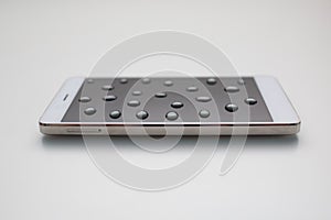 Mobile phone with drops on oleophobic screen.