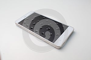 Mobile phone with drops on oleophobic screen.