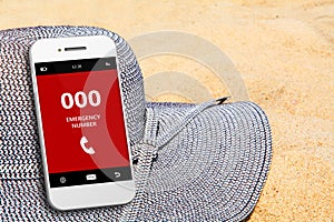 Mobile phone with emergency number 000 on the beach