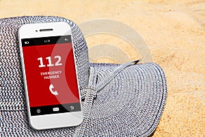 Mobile phone with emergency number 112 on the beach