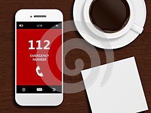 Mobile phone with emergency number 112 lying on desk