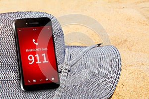 Mobile phone with emergency number 911 on the beach