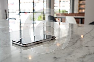 Mobile phone on granite table in blurred cafe