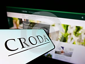 Mobile phone with logo of chamicals company Croda International plc on screen in front of business website.