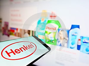 Mobile phone with logo of German chemical and consumer goods company Henkel on display in front of website.
