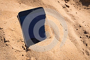 Mobile phone lost and lying in the sand