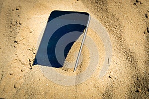 Mobile phone lost and lying in the sand