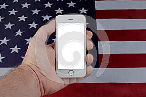 Mobile phone in a man's hand on the background of the usa flag