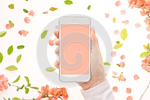 Mobile phone mock up in female hand with springtime decoration