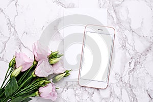 Mobile phone mock up with pink flowers on marble background