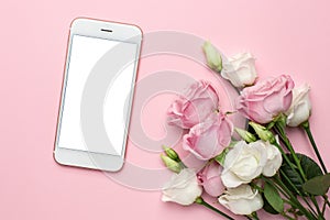 Mobile phone with pink and white roses flowers on pastel background.Minimalistic composition for the holidays,valentines day and