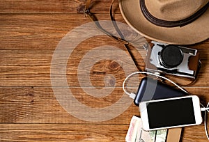 Mobile phone with powerbank on wooden table background.