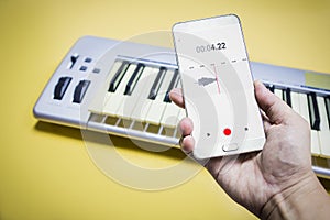 Mobile phone is recording the sound of man playing piano