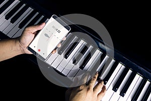 Mobile phone is recording the sound of man playing piano