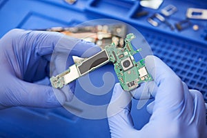 mobile phone repair. Repairman hands with microcircuit of smartphone