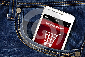 Mobile phone with shopping cart in jeans pocket photo