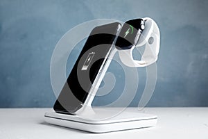 Mobile phone and charging with wireless pad on white stone table