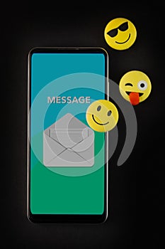 Mobile phone with smiley faces and emojis.