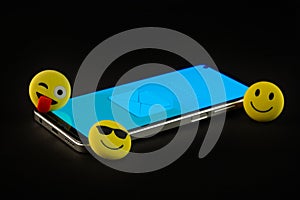 Mobile phone with smiley faces and emojis.