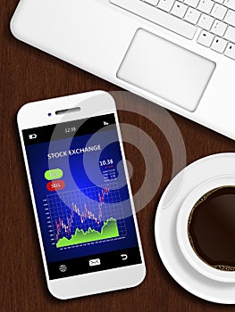 Mobile phone with stock chart, mug of coffee and laptop keyboard