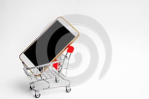 Mobile phone in a supermarket trolley. buying and selling a smartphone. online store. consumer credit. isolated white background