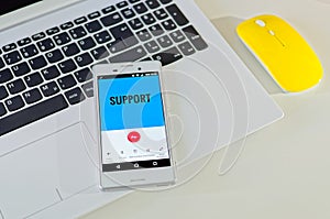 Mobile phone with support on the display and support called, with notebook, yellow mouse