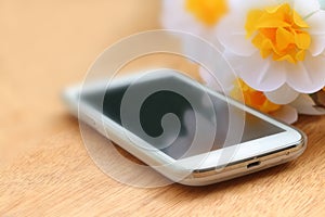 mobile phone on wooden ground with flower