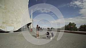 Mobile photo concept. Young man taking photos on mobile phone of his girlfriend having fun at the an empty city