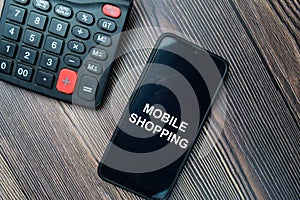 Mobile Shopping write on Smartphone isolated on office desk photo