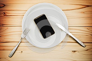 Mobile smart phone served as dinner on white plate