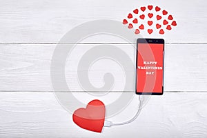 Mobile smart phone with sign Happy Valentines day charging
