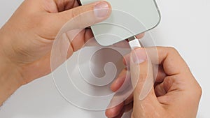 Mobile smart phones charging. Male hands plugging a charger in a smartphone on white background