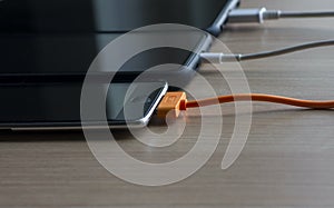 Mobile smart phones charging on wooden table