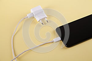 Mobile smartphone with charging on yellow background