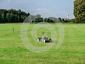 Mobile sprinkler on an empty soccer field on the countryside on the dry summer time
