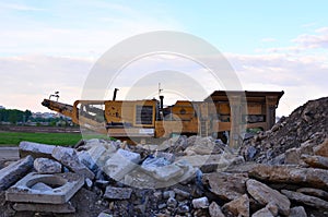 Mobile Stone crusher machine by the construction site or mining quarry for crushing old concrete slabs into gravel