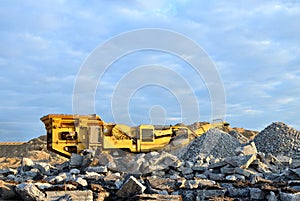 Mobile Stone crusher machine by the construction site or mining quarry for crushing old concrete slabs into gravel and subsequent