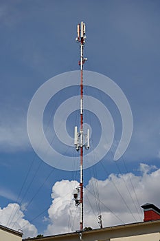 Mobile telephone radio network antenna on the building roof broadcasting signal over the city