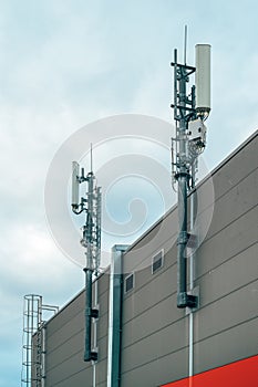 Mobile telephony base station and signal repeater antenna on industrial building photo